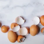 Gebroken eierschalen op een witte marmeren plaat klaar om te hergebruiken