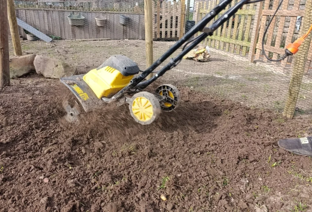 Grondfrees gebruiken om aarde luchtig te maken alvorens het zaaien van het gras