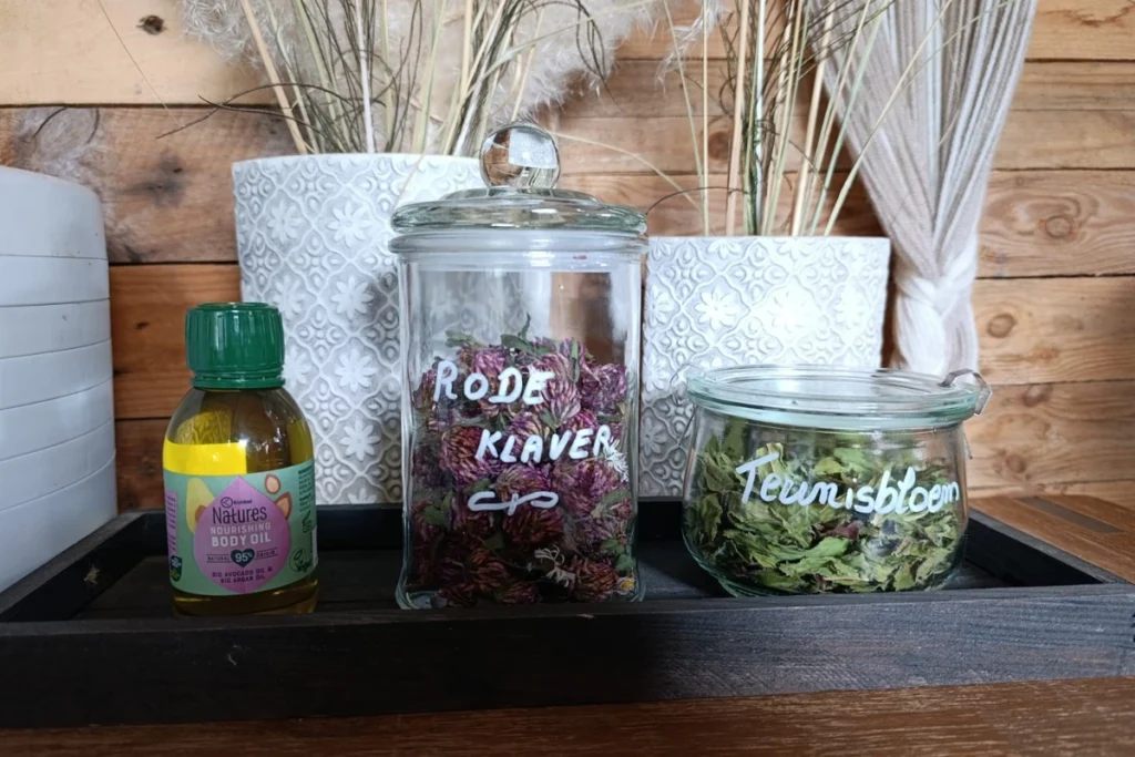 Benodigdheden voor het maken van rode klaver olie, een basisolie, gedroogde rode klaver en optioneel wat teunisbloem