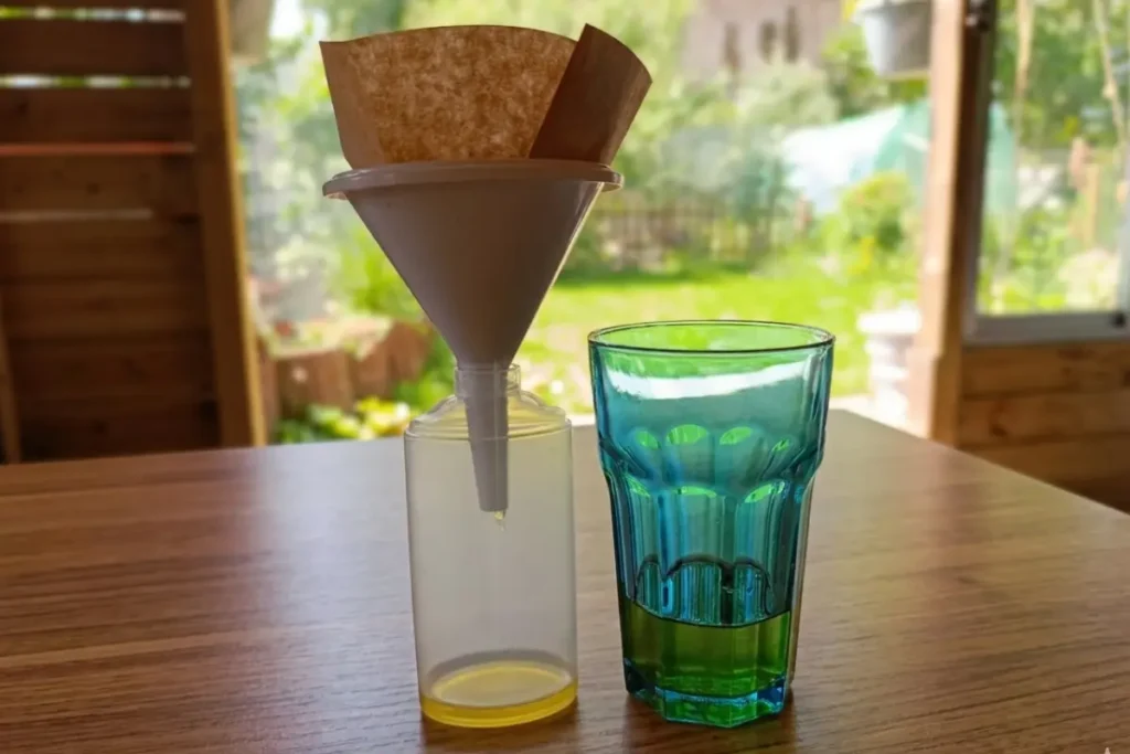 Fijn zeven van rode klaverolie, links zie je een glas met rode klaver olie die voor de eerste keer gezeefd is, links zie je hoe de olie een tweede keer gezeefd wordt in een trechter met filterzakje.